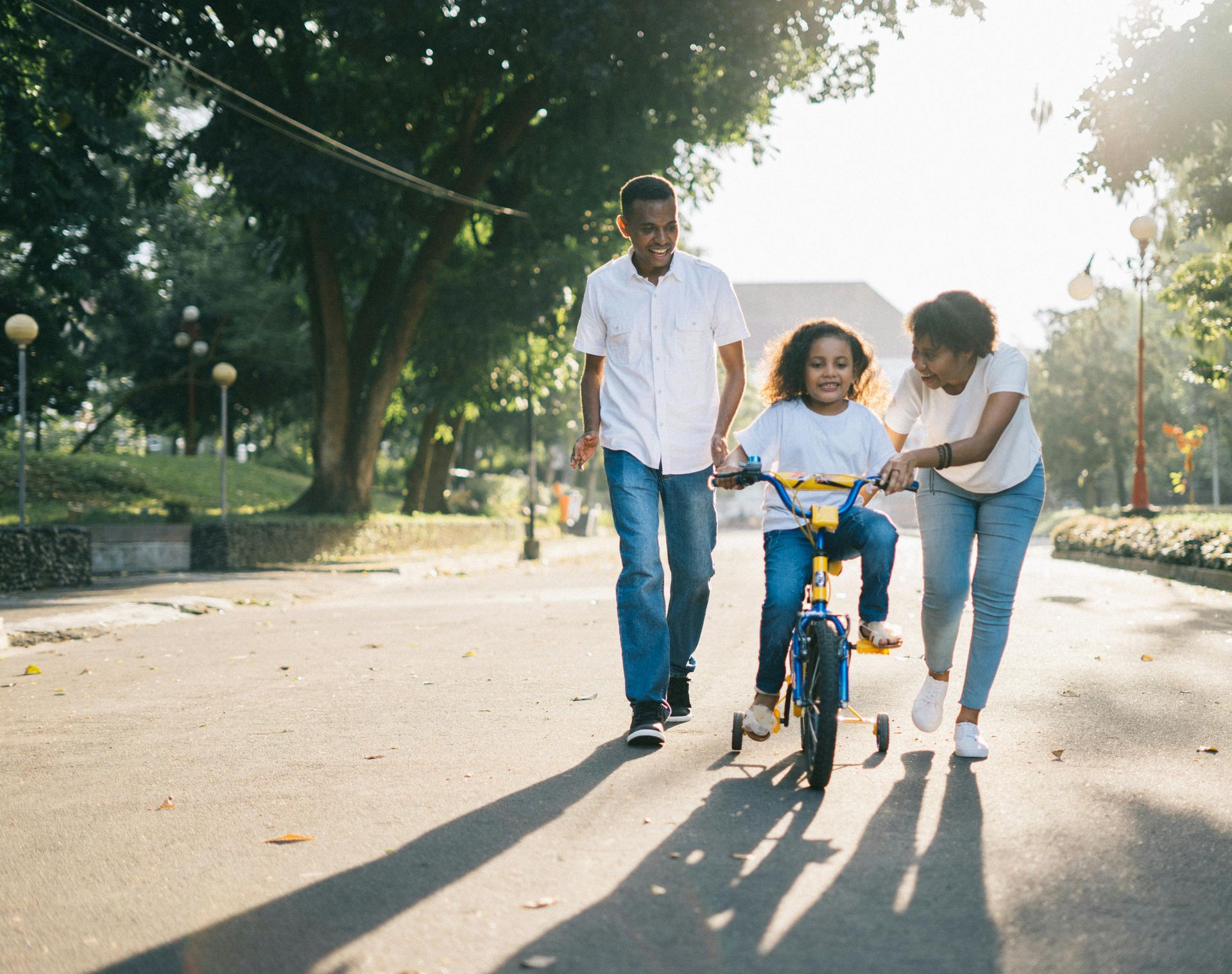 Ouders leren hun dochter fietsen in het park